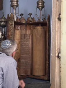 A photo of Rabbi Ron Segal in the beautiful Romaniote synagogue in Ioannina reading a 625 year old Torah